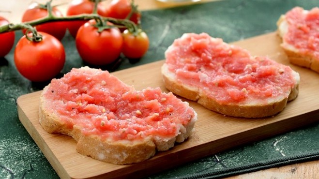 Imagem de três fatias de pão com tomate na superfície
