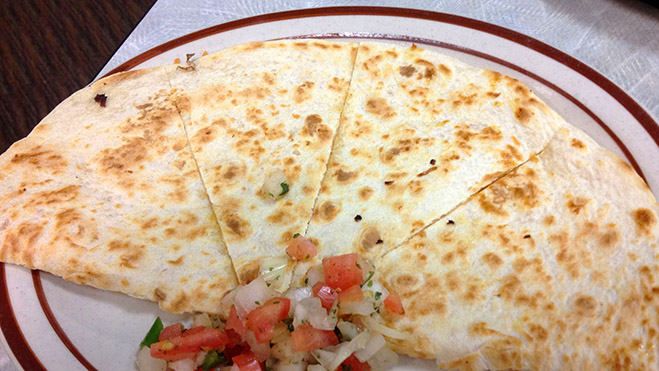 Quesadilla de queijo, alface e tomate em um prato redondo