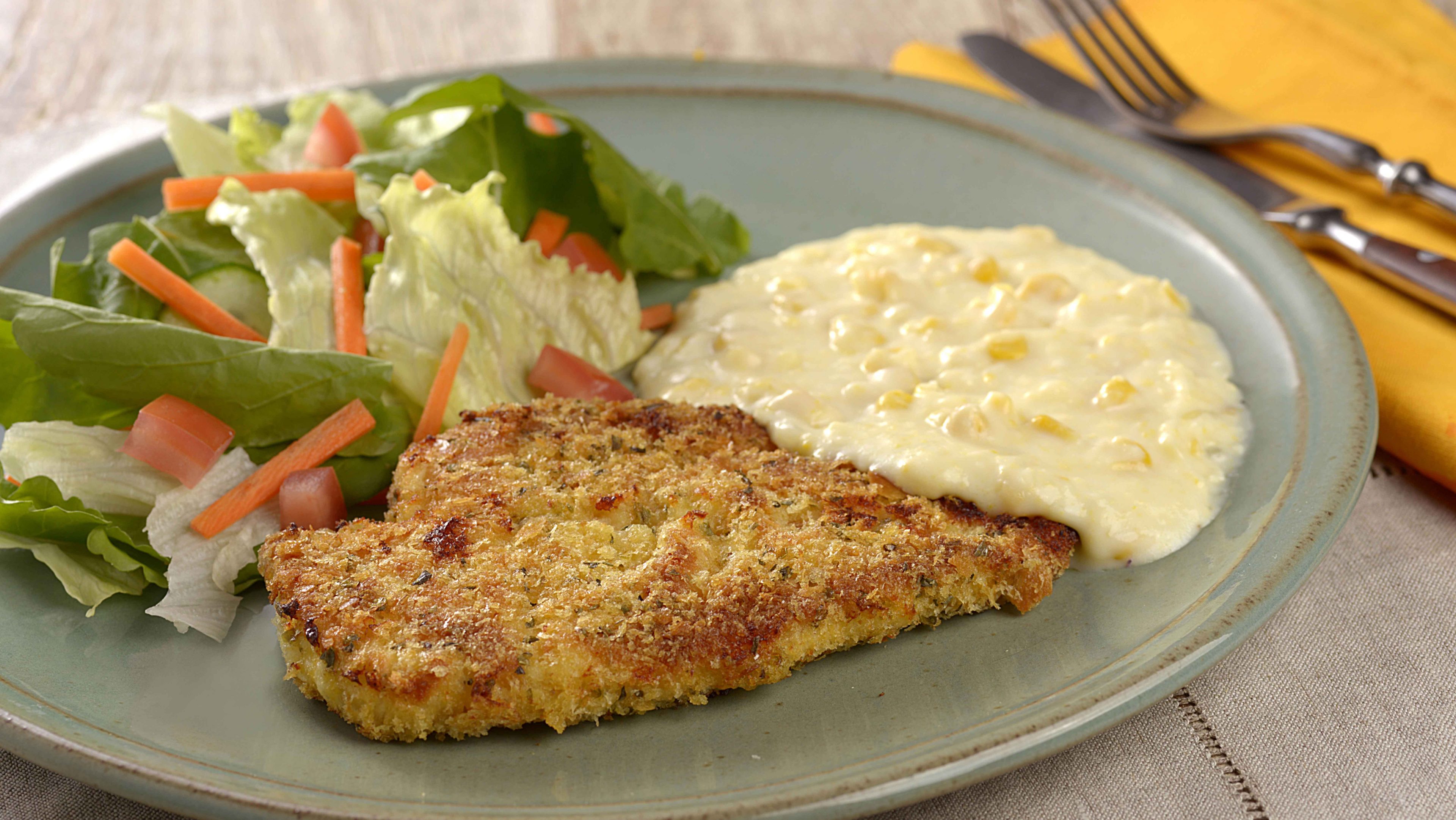 imagem de um prato com frango crocante, creme de milho e salada