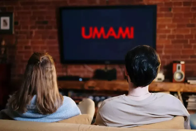 Duas pessoas no sofá assistindo a TV