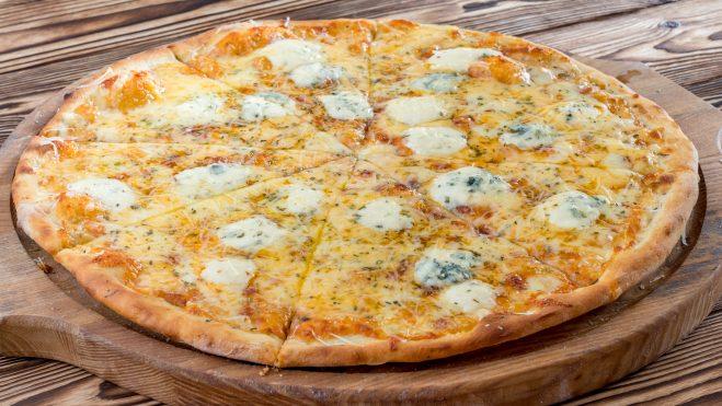 Tabua de madeira com pizza de quatro queijos