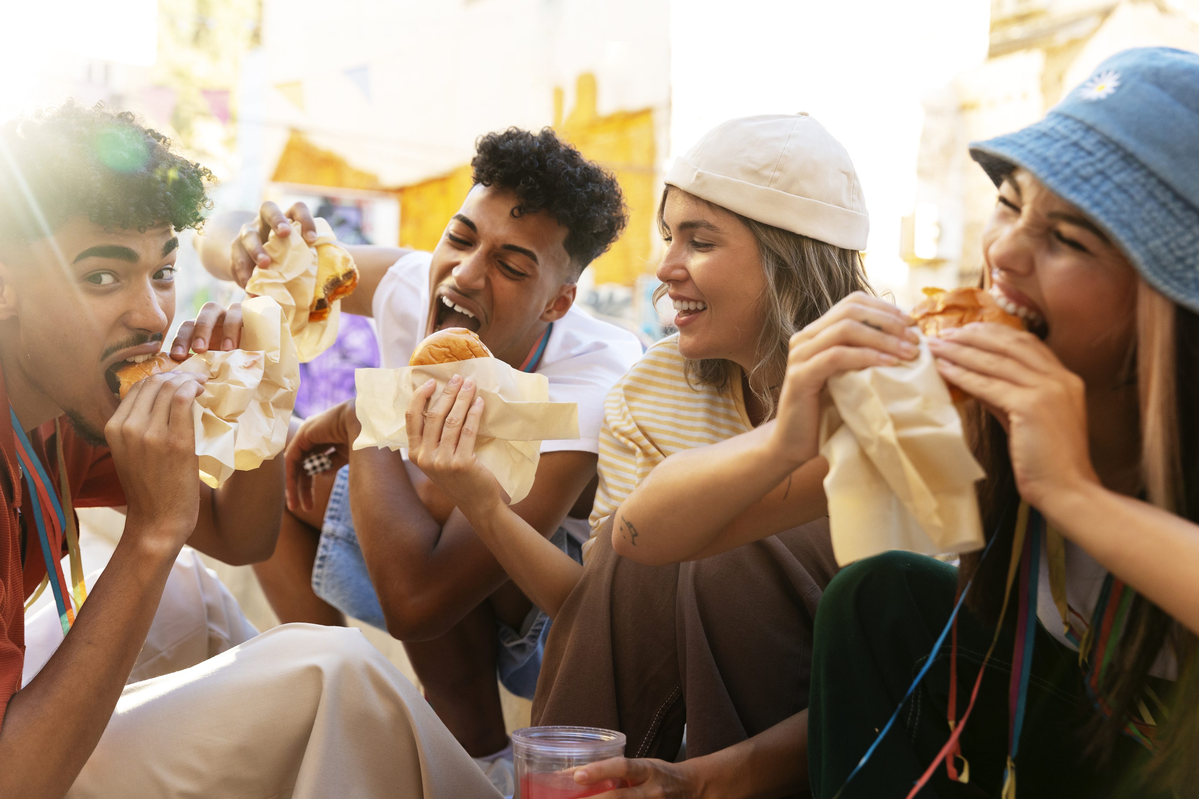 Quatro jovens comendo lanches em festival