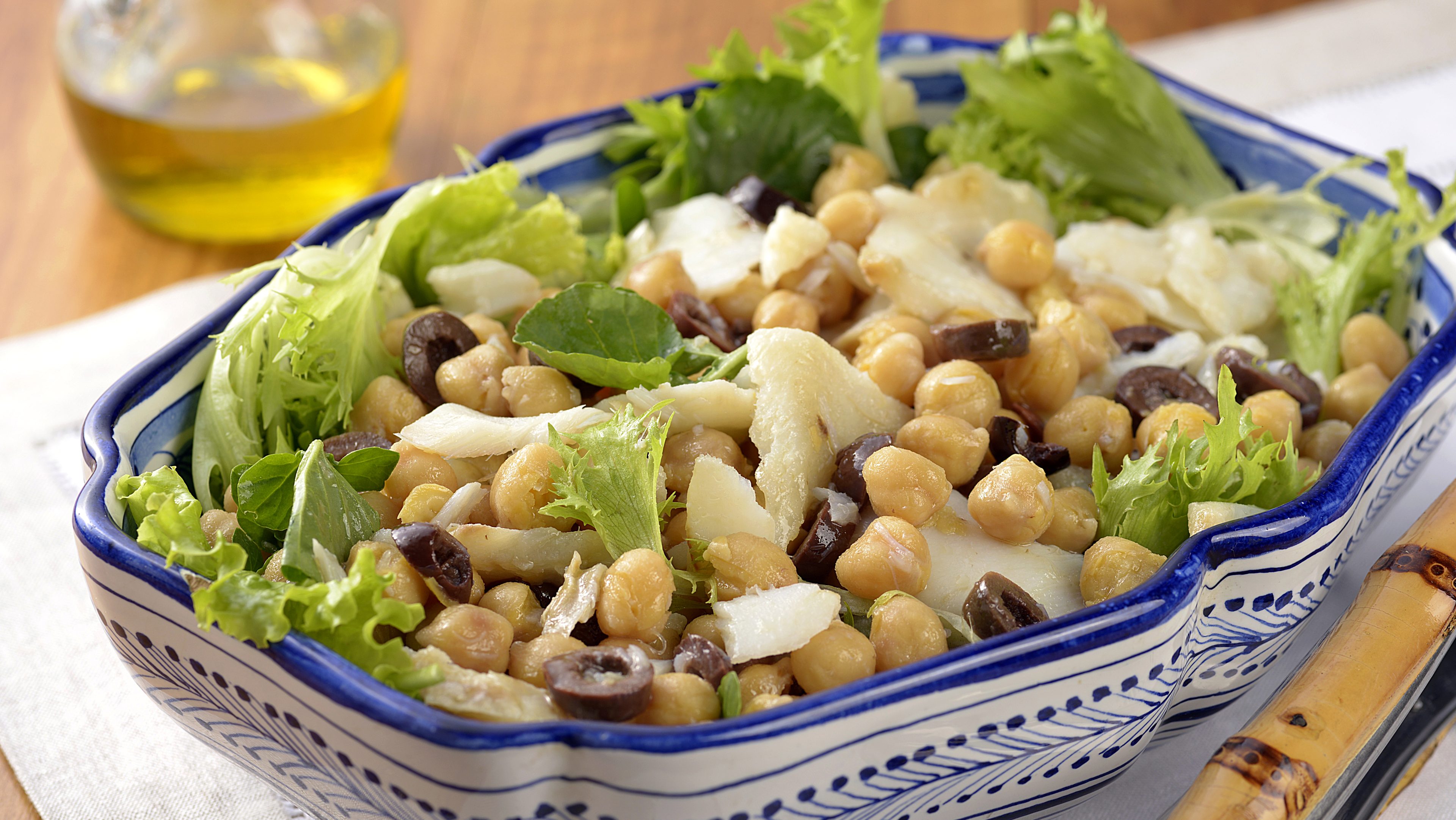 Salada portuguesa com grão de bico, bacalhau, azeitonas e mix de folhas